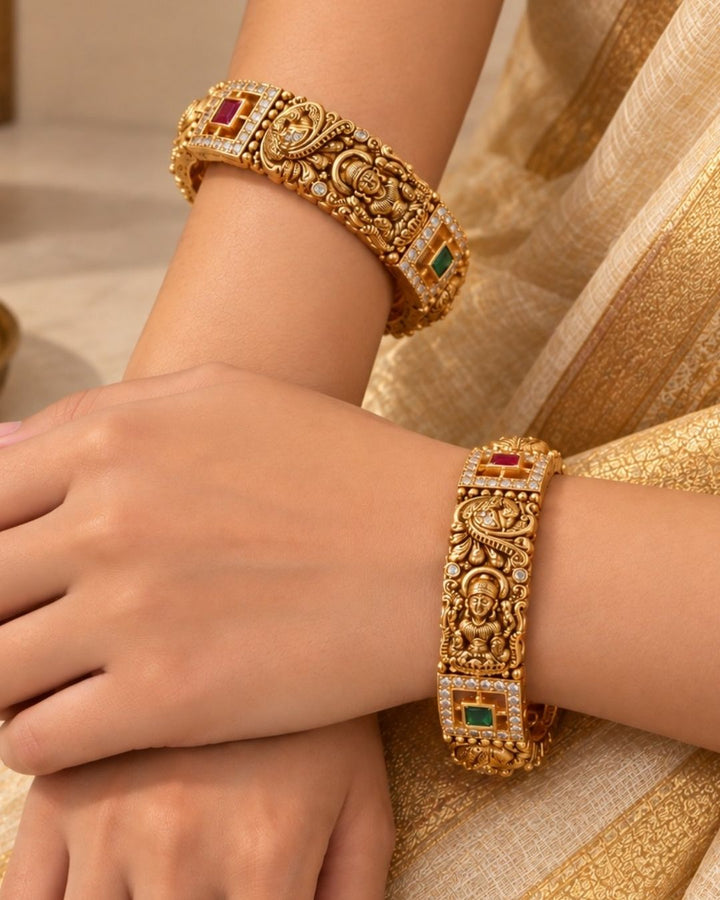 Elegant 18K gold plated designer bangles featuring Goddess Lakshmi and peacock motifs, colorful stones, and sparkling zircon borders, perfect for festive and traditional wear.