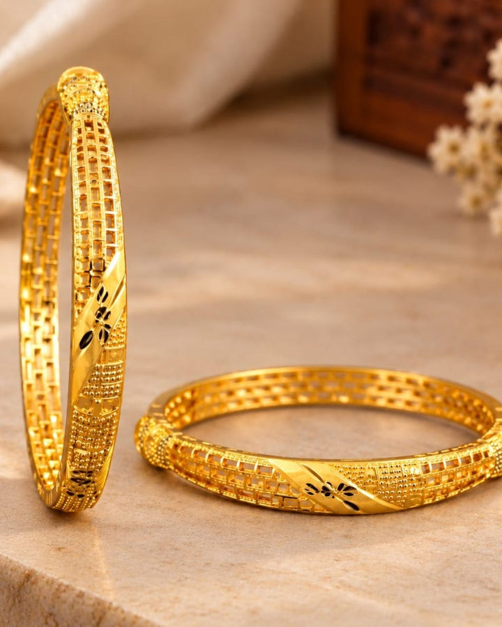 18K gold plated bangles featuring intricate geometric patterns, textured detailing, and black floral accents in an elegant traditional design.