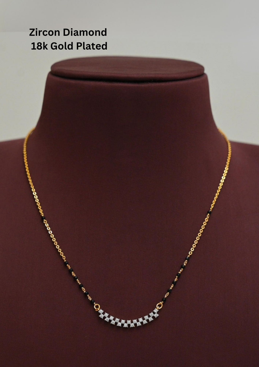 Modern Zircon Diamond gold plated mangalsutra necklace The design features a delicate gold long chain transitioning into sections of traditional small black beads on both sides. The central pendant showcases a sleek, contemporary curved Zigzag pendant with sparkling white cubic zirconia stones. This elegant neckpiece perfect for daily wear, office wear, and casual outfits.
