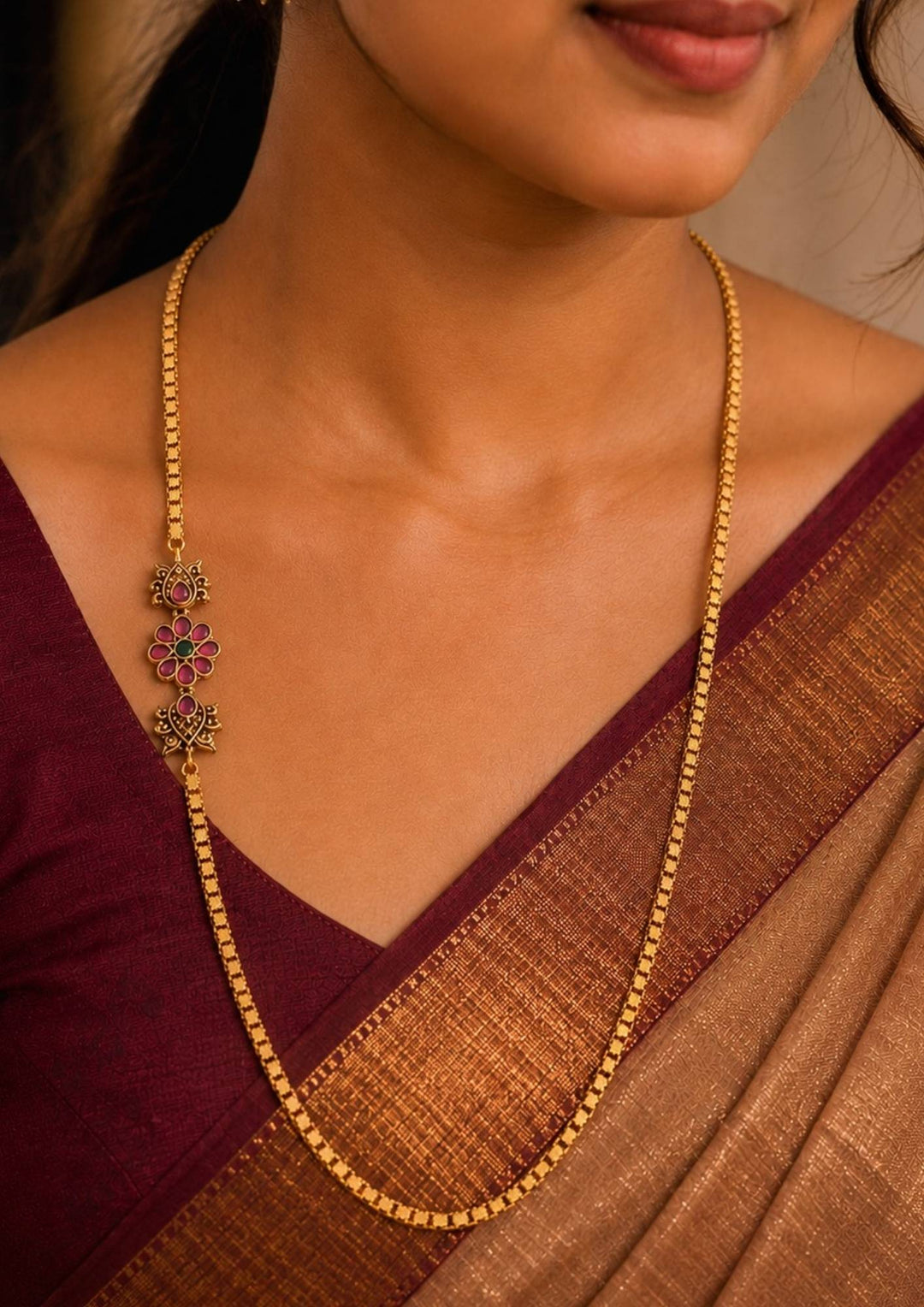 South Indian Women wearing This lightweight 18k gold-plated Mugappu Thali Chain features a durable, woven rope design accented by a sparkling diamond-and-ruby floral side pendant. It is perfect for daily wear, office environments, and casual family gatherings because the high-quality plating resists tarnishing from sweat and everyday use. Additionally, its classic, elegant look makes it an excellent choice for festive occasions, temple visits, and styling with traditional sarees or kurtis.
