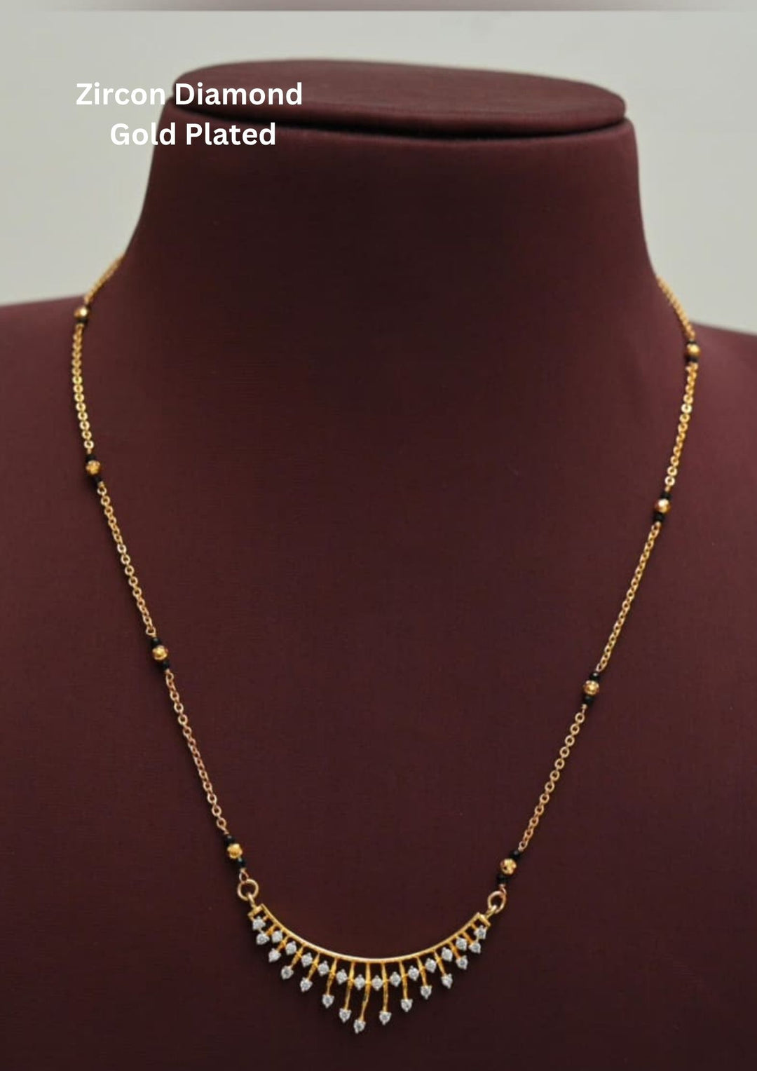 Elegant diamond replica black beads mangalsutra chain featuring a slim gold plated chain with evenly spaced traditional black beads and a curved center pendant decorated with tiny dangling zircon stones. The lightweight 18 to 20 inch necklace gives a modern minimal look suitable for daily wear, office wear, married women, festive occasions and traditional outfits.