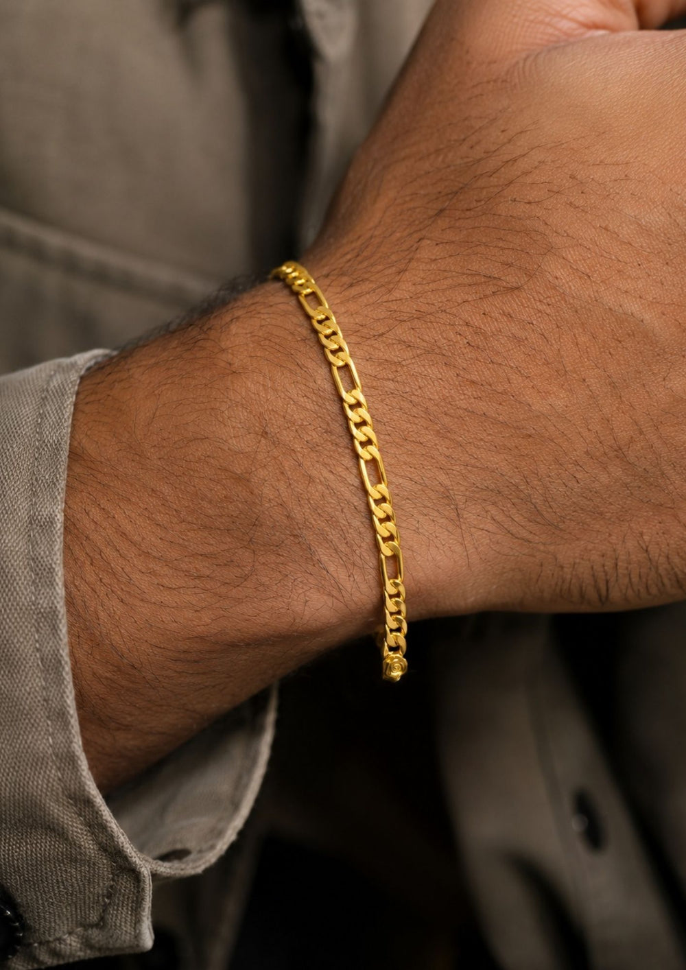 Close up of south indian men wrist wearing An elegant, sleek 18k gold-plated bracelet  features a continuous, sophisticated pattern of repeating cylindrical bar links seamlessly interconnected with small circular loops, offering a clean and polished modern look. Perfect for daily wear or for pairing with your favorite pendant.