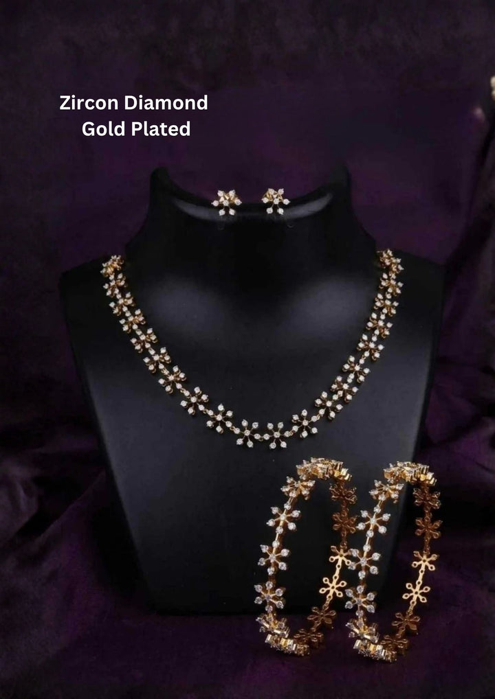 gold plated jewelry combo set featuring a delicate short choker necklace composed of linked starburst snowflake stations encrusted with white pure Zirconian diamonds. The set includes a matching pair of small star cluster ear studs and two thin matching filigree eternity bangles.