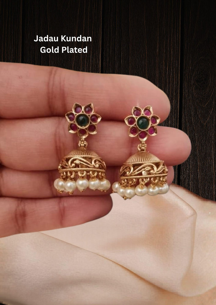 Gold-plated jhumka earrings with pearls and gemstones looks very traditional with flower design  