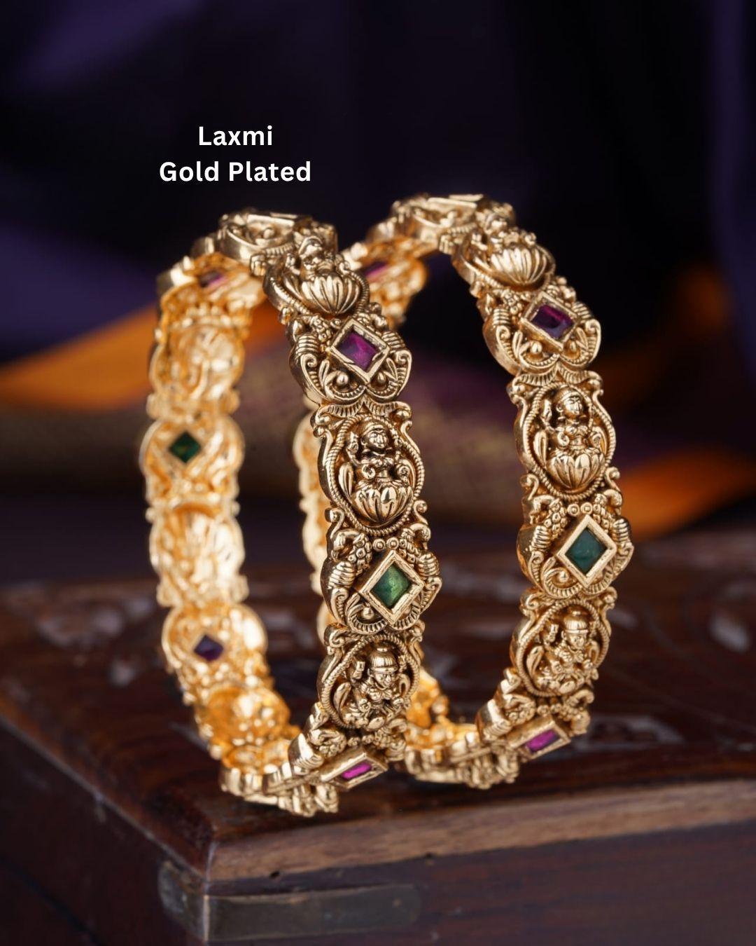 Traditional gold plated temple bangles with Goddess Lakshmi motifs, ruby pink and green square stones, and ornate antique-style craftsmanship.