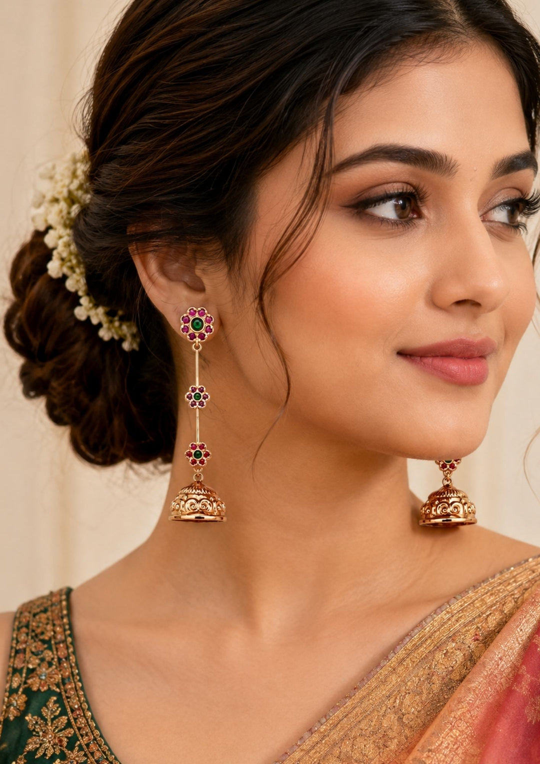Gold earrings with green and red stones worn by a south indian women looks very detailing and also women shows how it looks to every one very traditional 