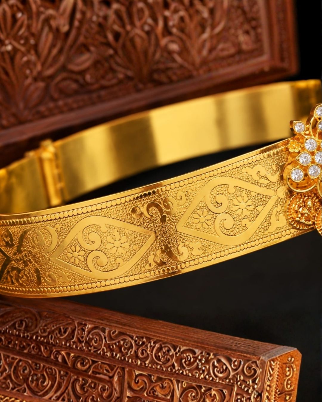 Elegant gold plated vaddanam with a floral crystal centerpiece and intricate detailing for festive and traditional wear.