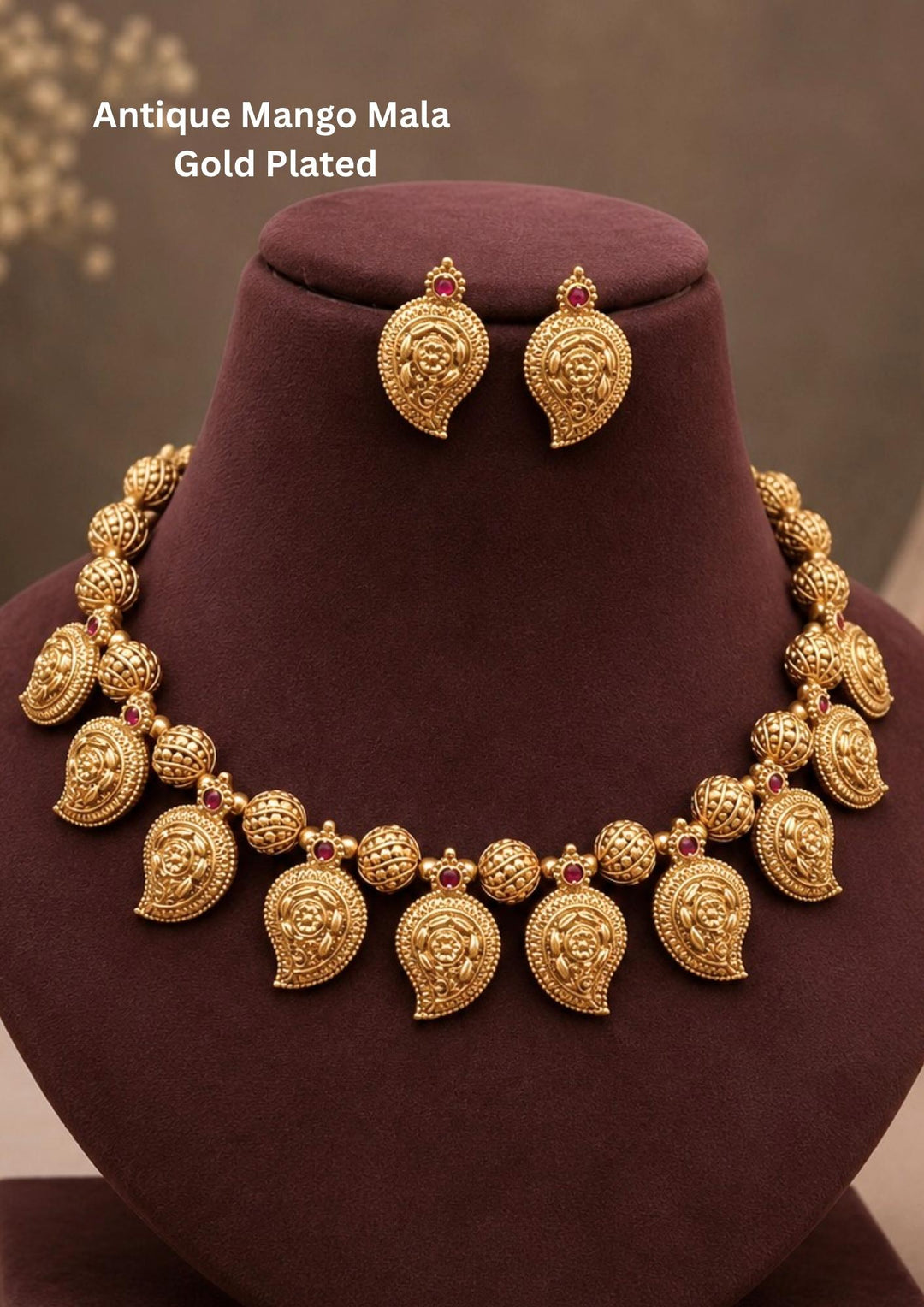 Traditional antique mango mala gold plated necklace and matching stud earrings The necklace features a classic South Indian layout made of textured gold bead spheres alternating with traditional paisley mango (manga) motifs decorated with intricate leaf carvings and tiny red ruby. Perfect for weddings, festivals.