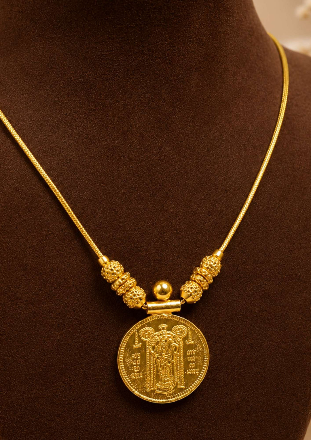 Exquisite God Balaji gold-plated coin necklace featuring intricate motif carvings and ruby-colored stone accents. Ideal for weddings, festive occasions, temple visits, traditional sarees, and bridal gifting.