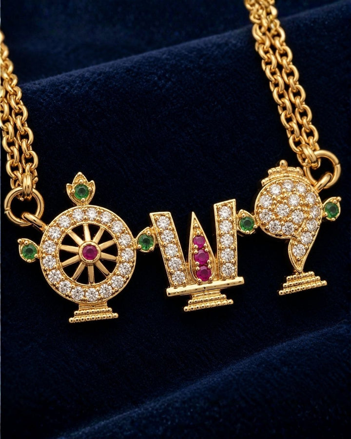Shanku Chakra Namam 18K gold plated chain necklace designed with white zircon diamonds with vibrant red and green stone highlights on the symbols. It has a premium gold finish, is lightweight, and comfortable to wear. Suitable for daily use, pooja, weddings, festivals, functions, and family occasions. It is sweat-proof, anti-fade, skin-friendly, and easy to wear for long hours.