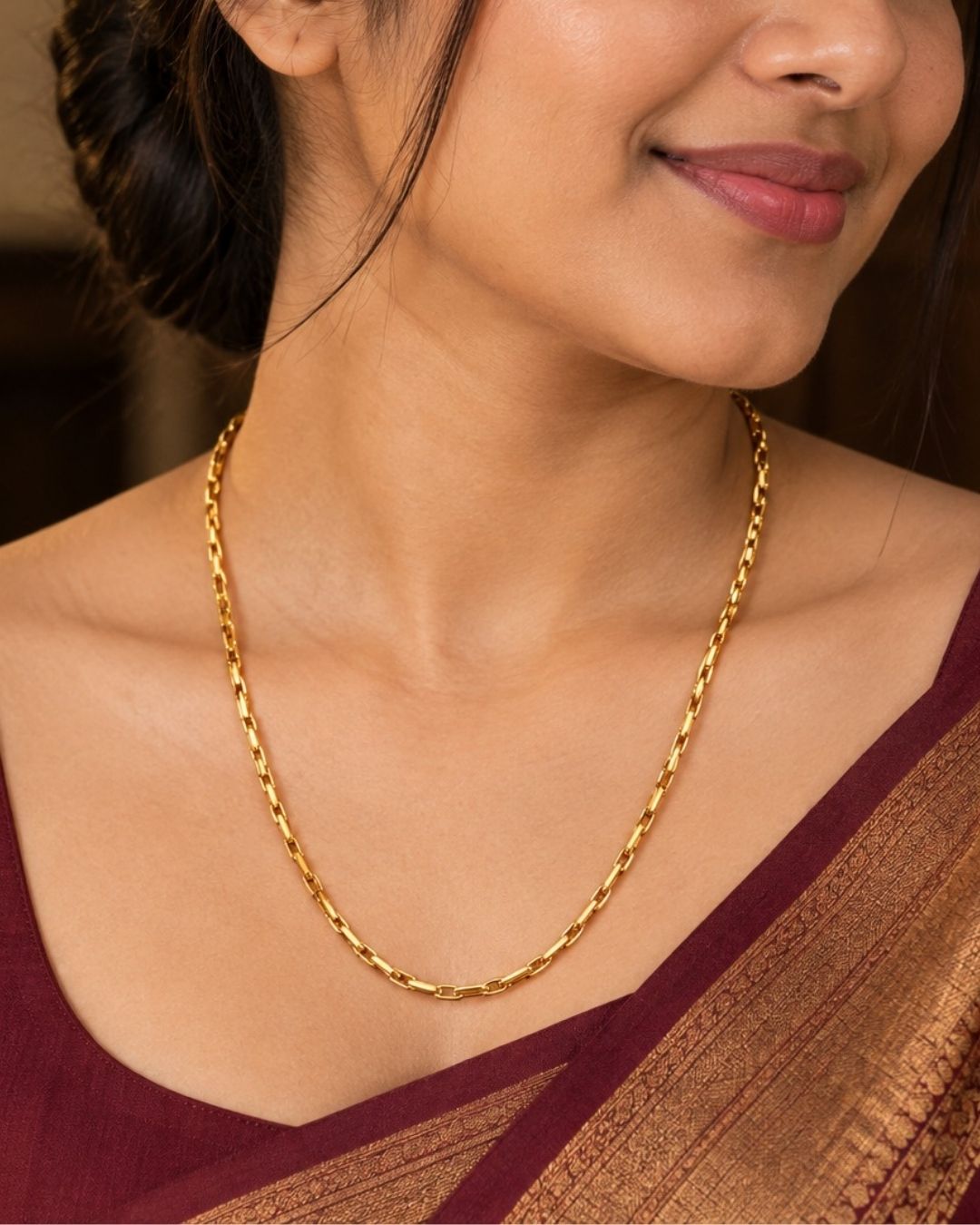 An elegant, sleek 18k gold-plated Mop chain displayed over a textured dark wooden surface. The chain features a continuous, sophisticated pattern of repeating cylindrical bar links seamlessly interconnected with small circular loops, offering a clean and polished modern look. Perfect for daily wear or for pairing with your favorite pendant.