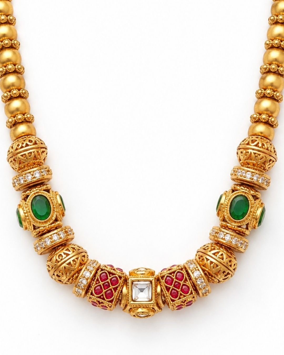 Close-up of a woman wearing Antique Gold Plated Beads Mala with traditional long chain pattern and detailed with gold bead work , green and red stones that gives a simple and elegant traditional jewelry look. The mala ihas a cibe shape pattern which is lightweight comfort, sweat proof finish, anti-fade colour, smooth fitting, and is suitable for festivals, pooja functions, family gatherings, and regular traditional wear.