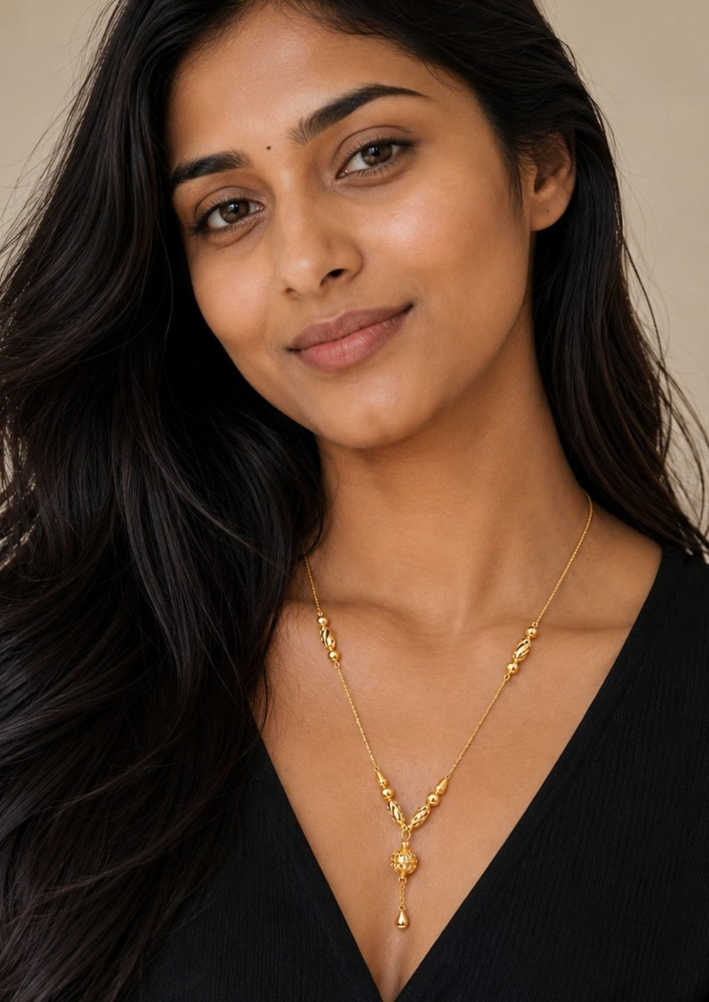 South Indian women wearing a Beautiful 18K gold plated necklace featuring polished gold beads and an elegant designer ball pendant with graceful hanging chain detailing. Lightweight, stylish, and perfect for everyday elegance.