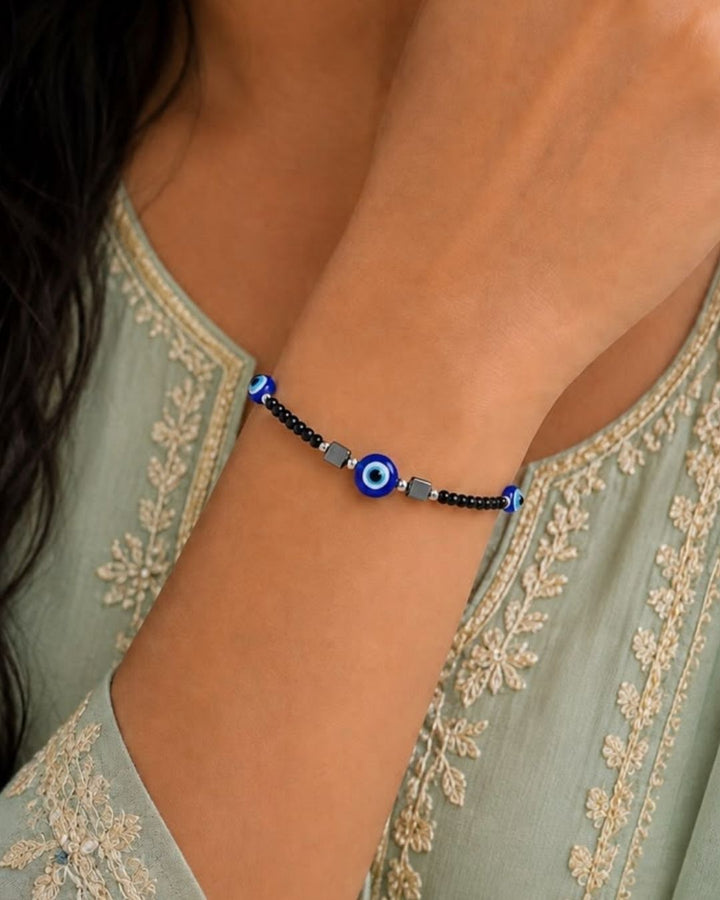 Trendy black beaded evil eye bracelet featuring faceted black beads, three vibrant blue evil eye charms, silver-tone accents, and geometric black elements. Perfect for everyday wear, casual outfits, gifting, and special occasions.