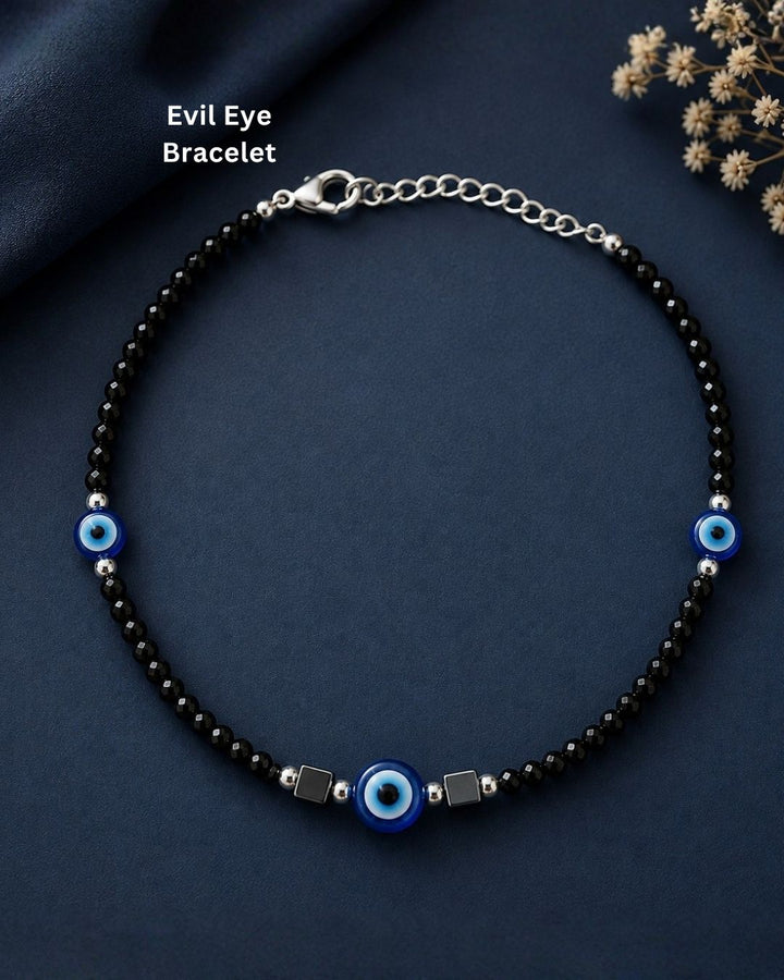 Trendy black beaded evil eye bracelet featuring faceted black beads, three vibrant blue evil eye charms, silver-tone accents, and geometric black elements. Perfect for everyday wear, casual outfits, gifting, and special occasions.