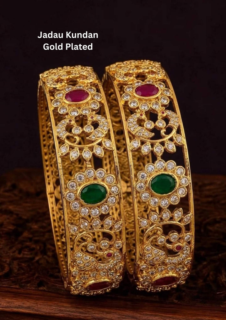 Premium gold plated temple bangles featuring peacock motifs, ruby and emerald stones, sparkling kundan work, and intricate traditional craftsmanship.