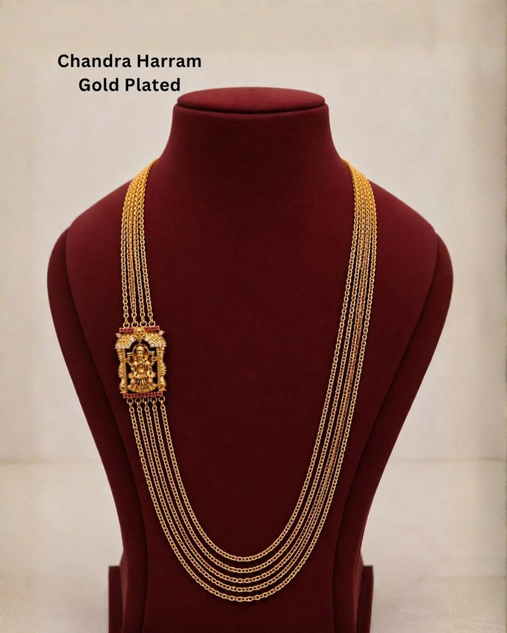 Beautiful traditional gold plated necklace featuring multiple layered chains and a detailed goddess pendant with red and green accents. Perfect for festive occasions, traditional outfits, weddings, parties, and gifting.