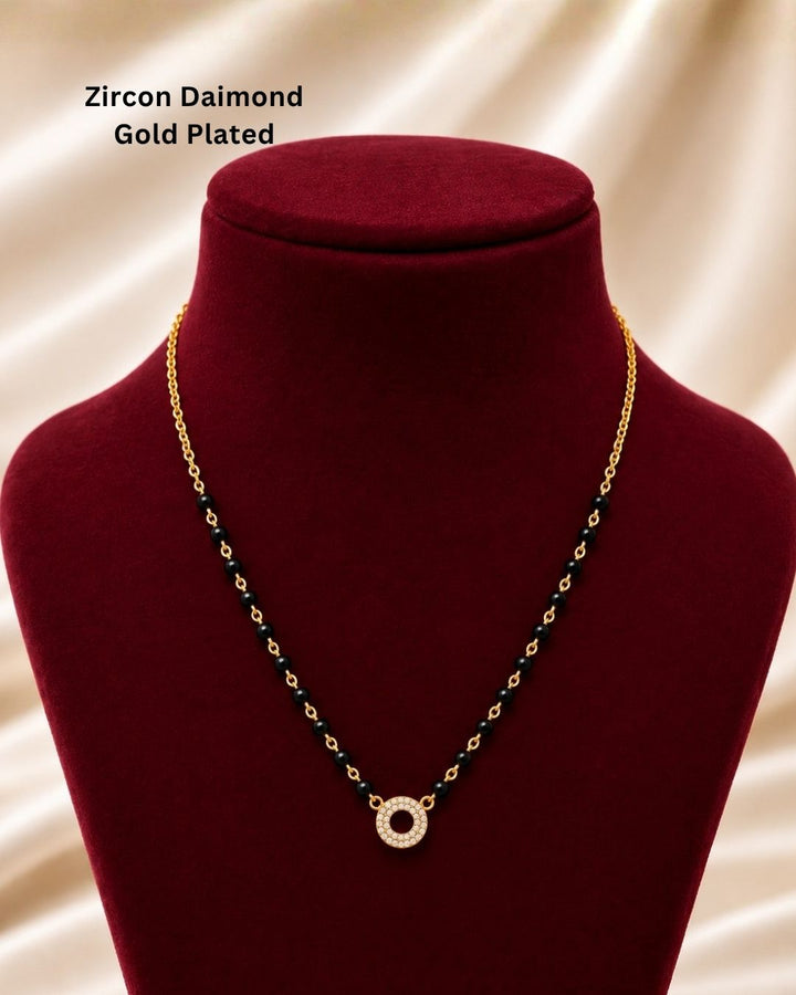 South indian Women wearing Gold plated black bead mangalsutra with a circular stone pendant displayed on a beige surface with a minimal decorative background.
