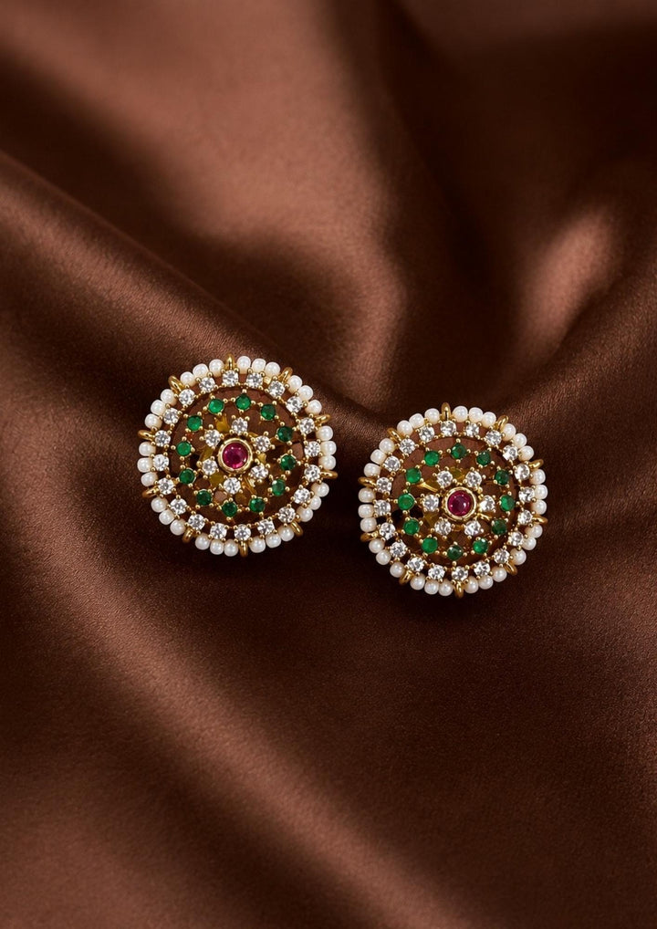 Elegant Jadau Kundan gold-plated stud earrings styled with traditional floral cluster patterns, with Emerald Green stone settings, and a pearl halo. Perfect for festive celebrations, weddings, ethnic wear, and luxury gifting.