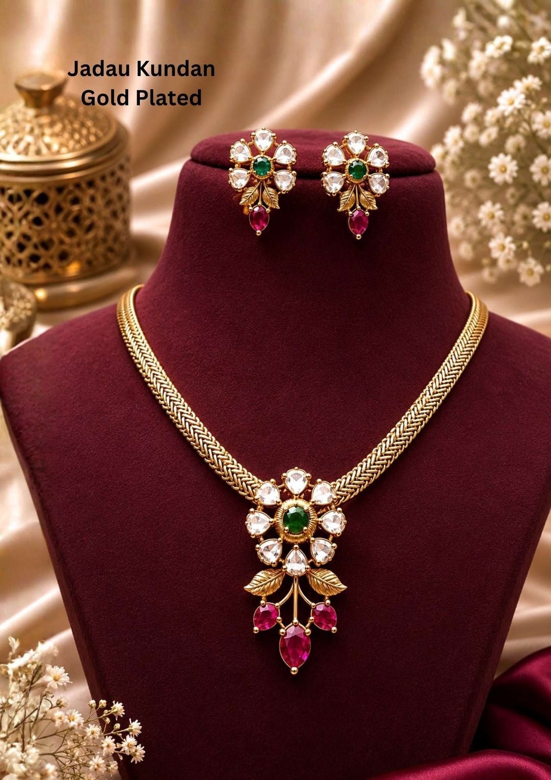 gold plated jewelry set featuring a flat mesh choker chain with a floral cluster pendant made of uncut glass diamonds, a deep green emerald center stone, and dangling pink ruby drops with gold leaf accents. This lightweight traditional brass base jewelry set is crafted with a premium antique gold finish that provides a rich royal appearance suitable for weddings, festivals, poojas, family functions, sarees, lehengas, and ethnic outfits with skin-friendly quality, anti-fade polish, comfortable fitting