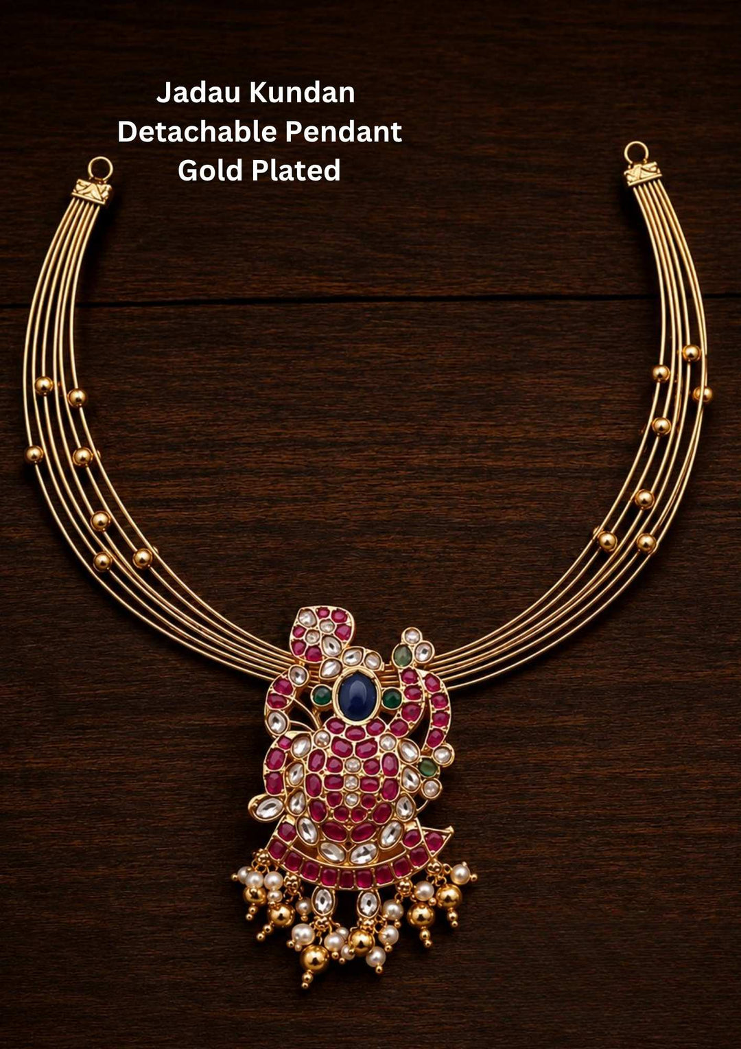 : Gold plated Hasli necklace featuring a rigid five-line golden wire collar with small gold beads. A large detachable peacock pendant sits at the center, decorated with pink stones, clear kundan crystals, a central blue stone, green stone accents, and a row of hanging gold beads and white pearls along the bottom edge, providing a premium heritage appearance suitable for festive wear and traditional occasions.