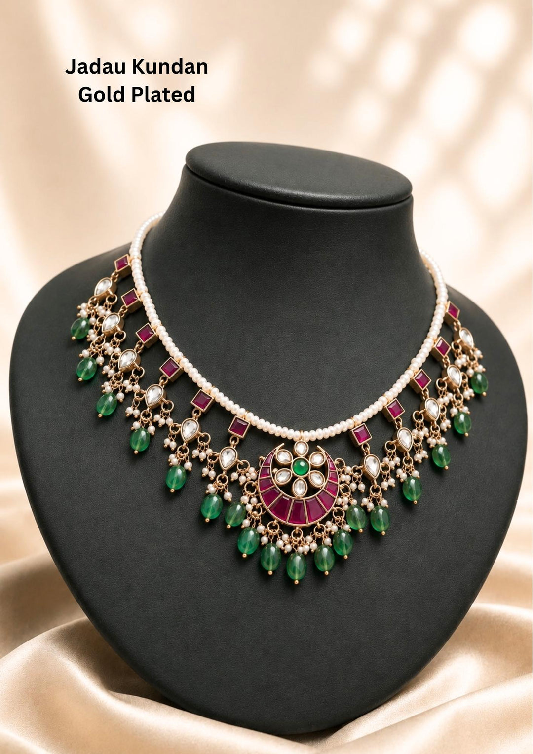 gold plated Jadau choker necklace featuring a delicate single strand of white pearls integrated with a vibrant pink square stone border, a central crescent chandbali floral pendant, and dangling green emerald bead clusters accented by tiny pearl bunches. This lightweight traditional necklace is crafted with a premium gold finish that provides a rich royal appearance suitable for weddings, festivals, poojas, family functions, sarees, lehengas, and ethnic outfits with skin-friendly quality, anti-fade polish, 