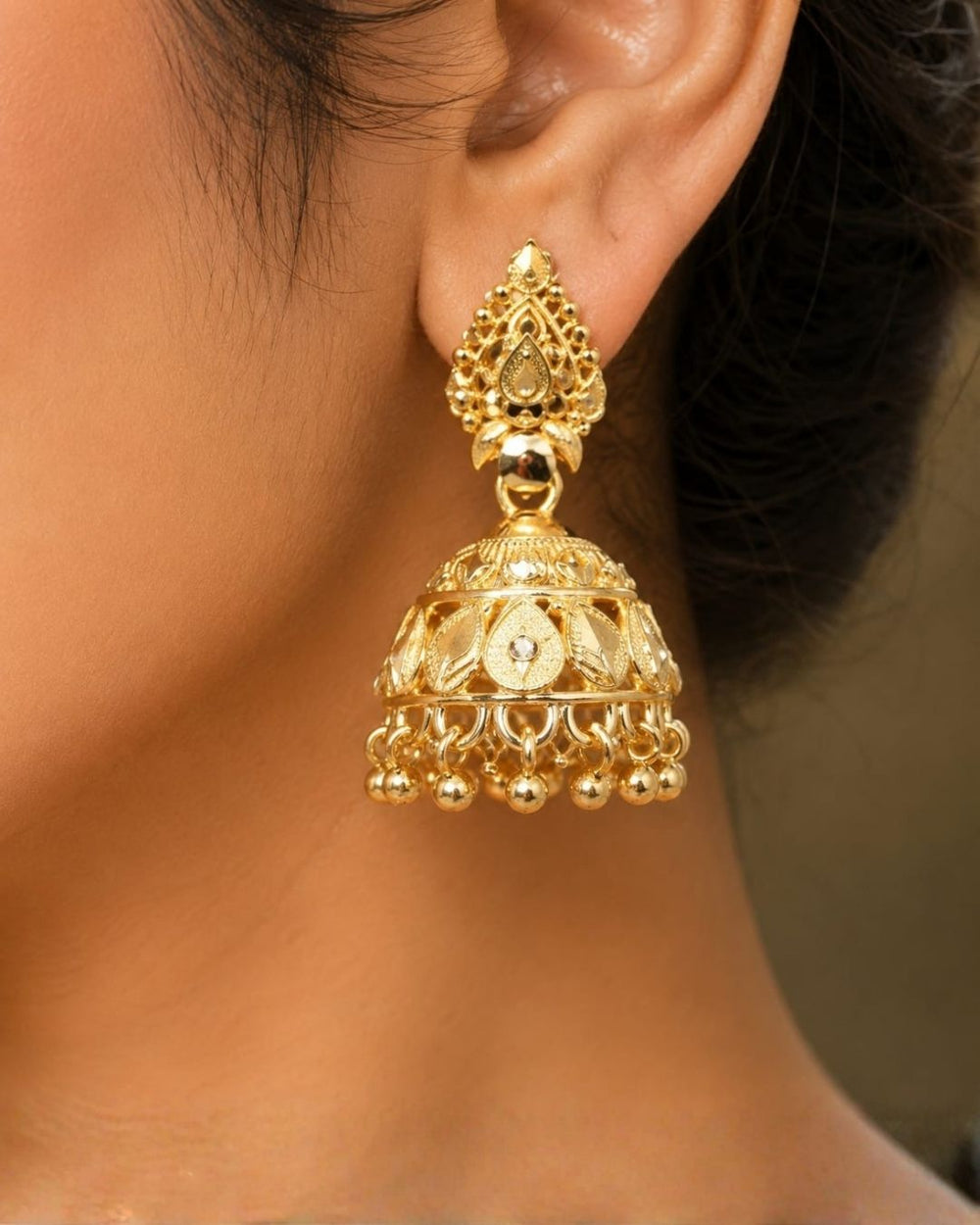 Premium gold plated traditional jhumka earrings featuring intricate ethnic craftsmanship, ornate dome-shaped designs, floral detailing, and elegant hanging gold bead accents. Perfect for sarees, festive occasions, weddings, classical dance performances, and traditional events.