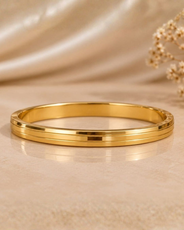 Stylish gold plated women’s kada featuring a sleek triple-line design, smooth polished finish, and elegant minimalist look, perfect for daily wear, festive occasions, and modern traditional outfits.