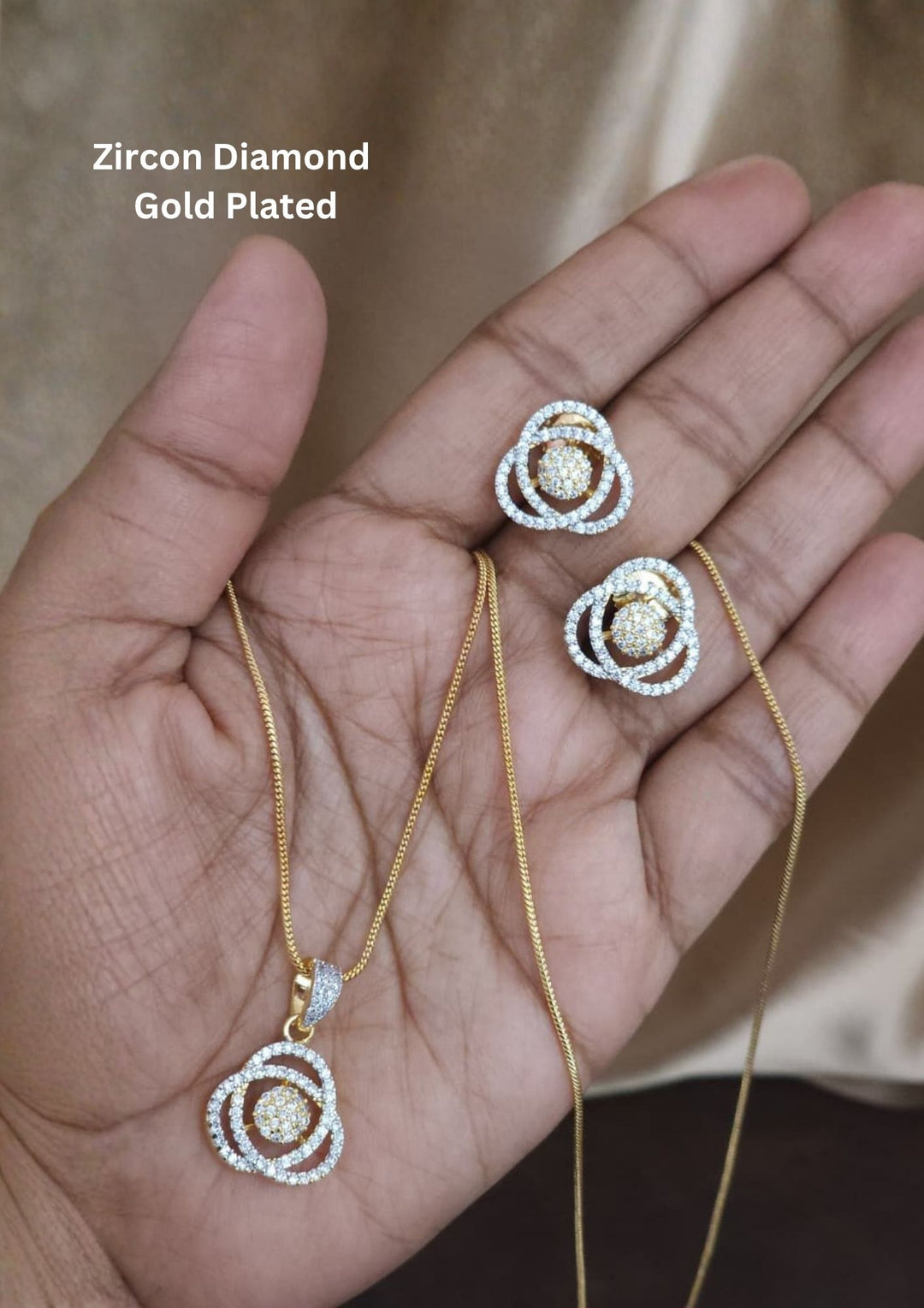 Zircon diamond gold plated pendant set design with sparkling white zircon stones in an elegant layered rose flower pattern with premium gold plated finish and sleek lightweight chain design. The pendant and earrings showcase a modern rose inspired circular floral model with micro zircon detailing at the center, giving a rich diamond look suitable for daily wear, office wear, parties, casual outings, festivals.