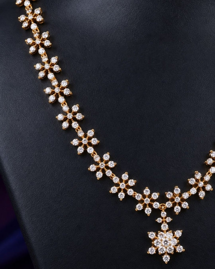 Zirconian Diamond Gold Plated long chain necklace and matching stud earrings set. The jewelry designed with floral pattern made of sparkling cube zirconia stones on a gold-plated base for festivals, temple visits, weddings, functions and dailywear