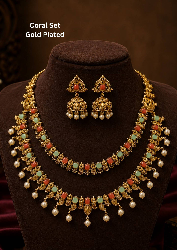 Traditional coral gold plated necklace featuring coral stones, pearl drops and intricate handcrafted detailing for an elegant festive appearance jhumka earrings featuring intricate antique detailing with pearl drops Perfect for weddings, festivals and ethnic celebrations.