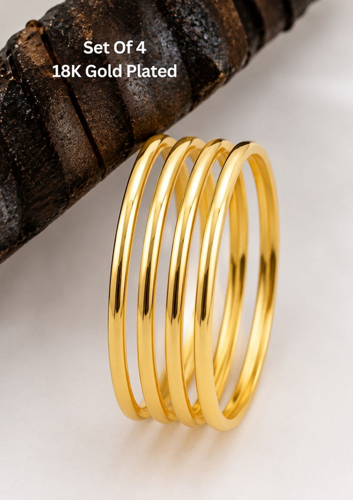 Four slim gold-plated rings stacked together Classic gold plated bangles with intricate engraved detailing for a timeless traditional look.