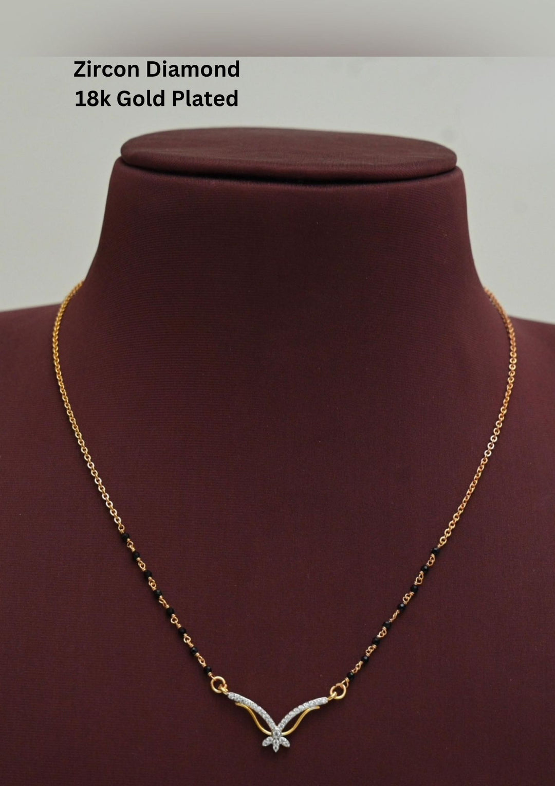 Gold plated black beads mangalsutra featuring an elegant butterfly-inspired zircon centerpiece with delicate curved detailing. Lightweight and beautifully crafted for everyday elegance, festive occasions, and gifting.