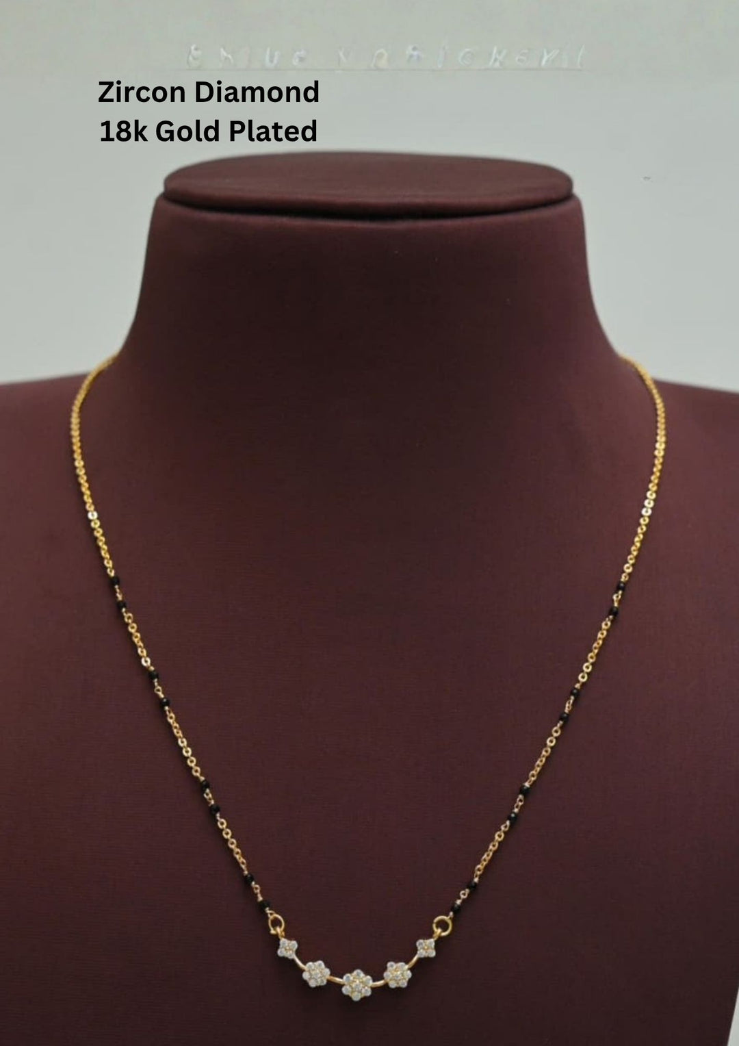 Gold plated black beads mangalsutra featuring delicate floral zircon motifs beautifully arranged along the centerpiece. Designed with a lightweight 16–18 inch chain, perfect for everyday elegance and festive styling.