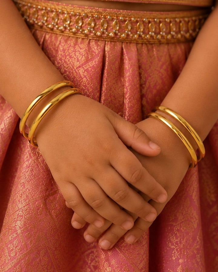 Four slim gold-plated rings stacked together Classic gold plated bangles with intricate engraved detailing for a timeless traditional look.