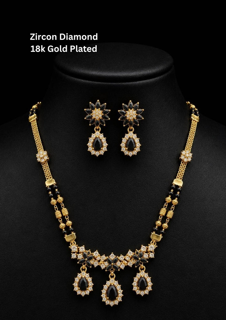Elegant zircon diamond gold plated mangalsutra featuring black beads, sparkling CZ stones, and matching drop earrings for a graceful bridal look.