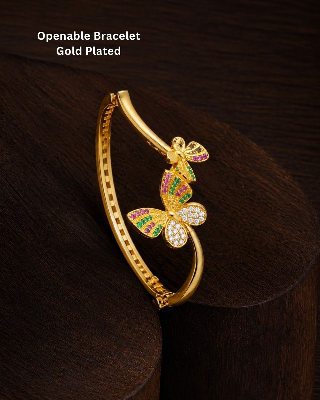Traditional gold plated bangle and jhumka earrings set featuring CZ stones, green gemstones, pink accents, pearl hangings, and a luxurious velvet presentation for festive occasions.