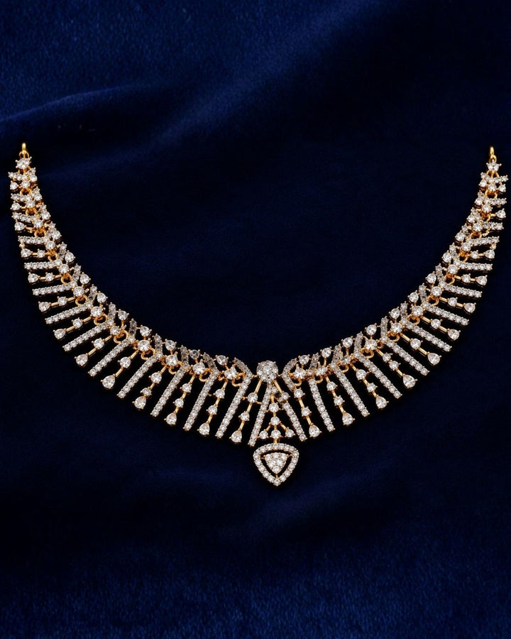 gold plated V-shaped collar necklace with a modern Art Deco aesthetic. The structured necklace features alternating diagonal bars encrusted with micro pure Zirconian diamonds, creating a shimmering chevron fringe that culminates in a central teardrop crystal pendant, complete with matching drop earrings.
