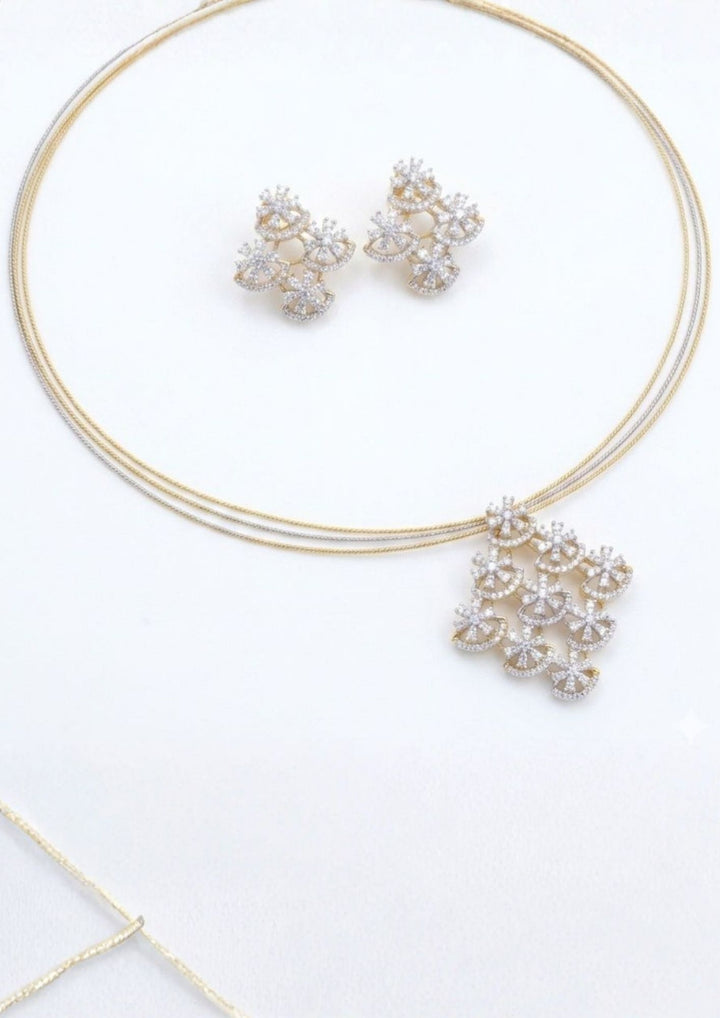 A modern zirconian diamond 18K gold-plated sleek pendant and earring set highlighting clean lines and star-like clusters. The jewelry features sparkling diamond-like star elements arranged in a cascading geometric pendant, making it an excellent match for silk sarees, chic lehengas, evening gowns, and modern festive wear at receptions or parties.