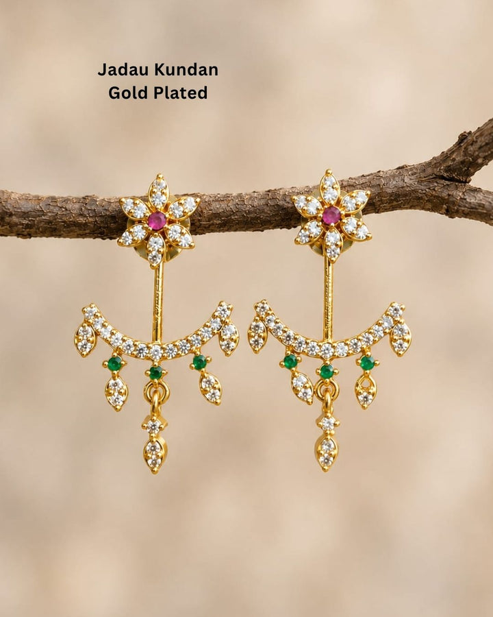 Beautiful gold plated designer dangler earrings featuring intricate floral detailing, sparkling CZ stones, pink and green accents, and delicate hanging drops. Perfect for festive occasions, parties, traditional wear, and gifting.