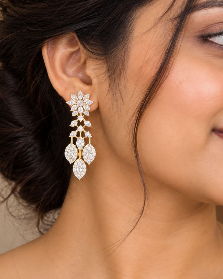 Designer gold plated long necklace and matching earrings featuring intricate leaf motifs embellished with sparkling white stones, perfect for festive, wedding, and traditional occasions.