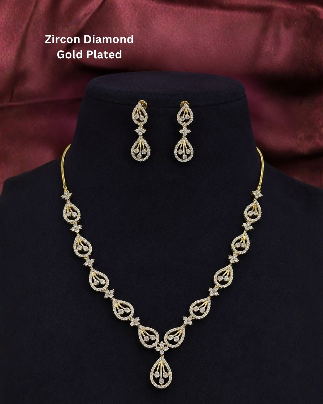 Designer gold plated CZ necklace set with shimmering teardrop patterns, floral connectors, and matching drop earrings, perfect for festive and party wear.