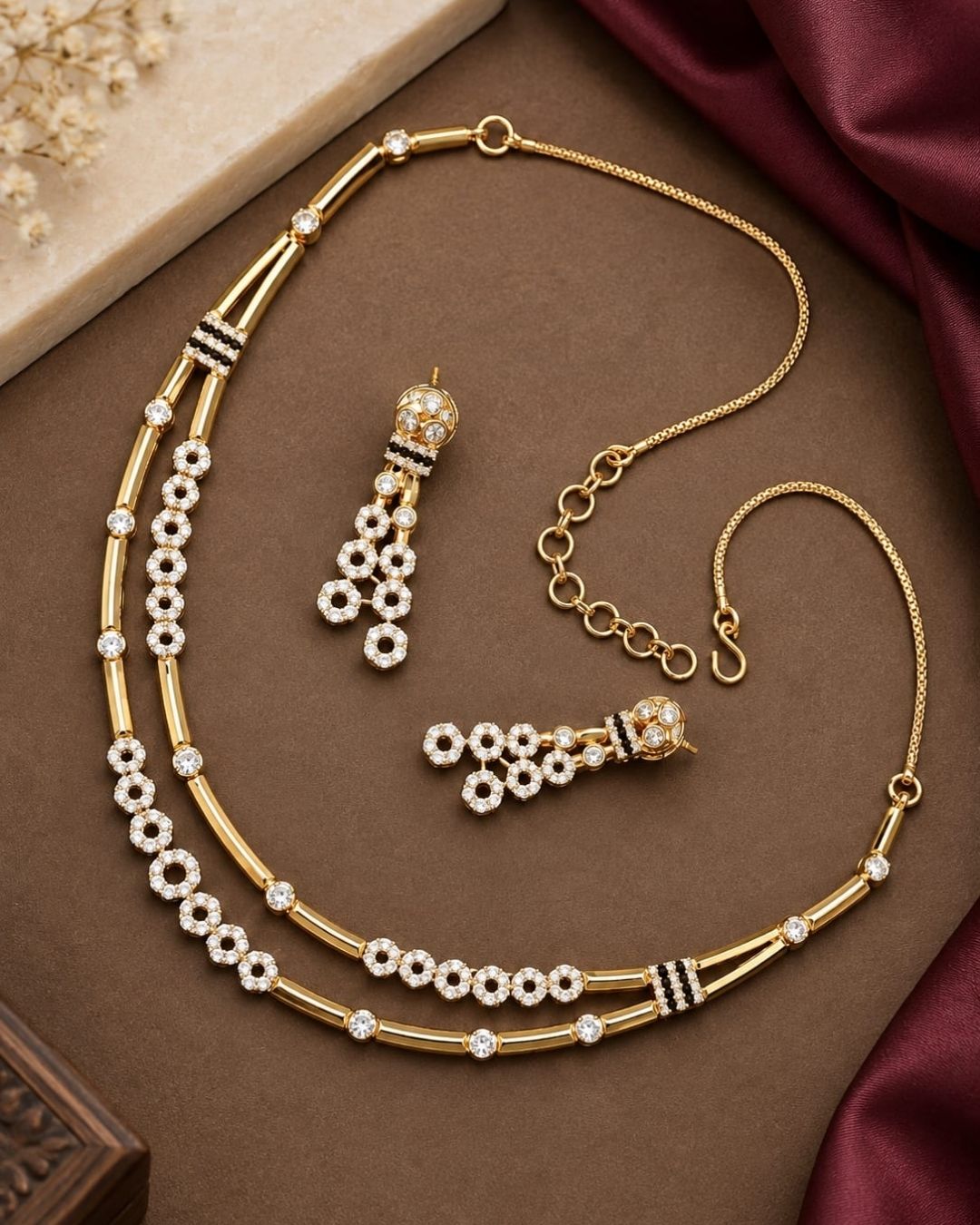 Stylish gold plated necklace set featuring layered gold-tone chains, sparkling circular stone embellishments, and matching dangling earrings, perfect for festive, party, and traditional occasions.