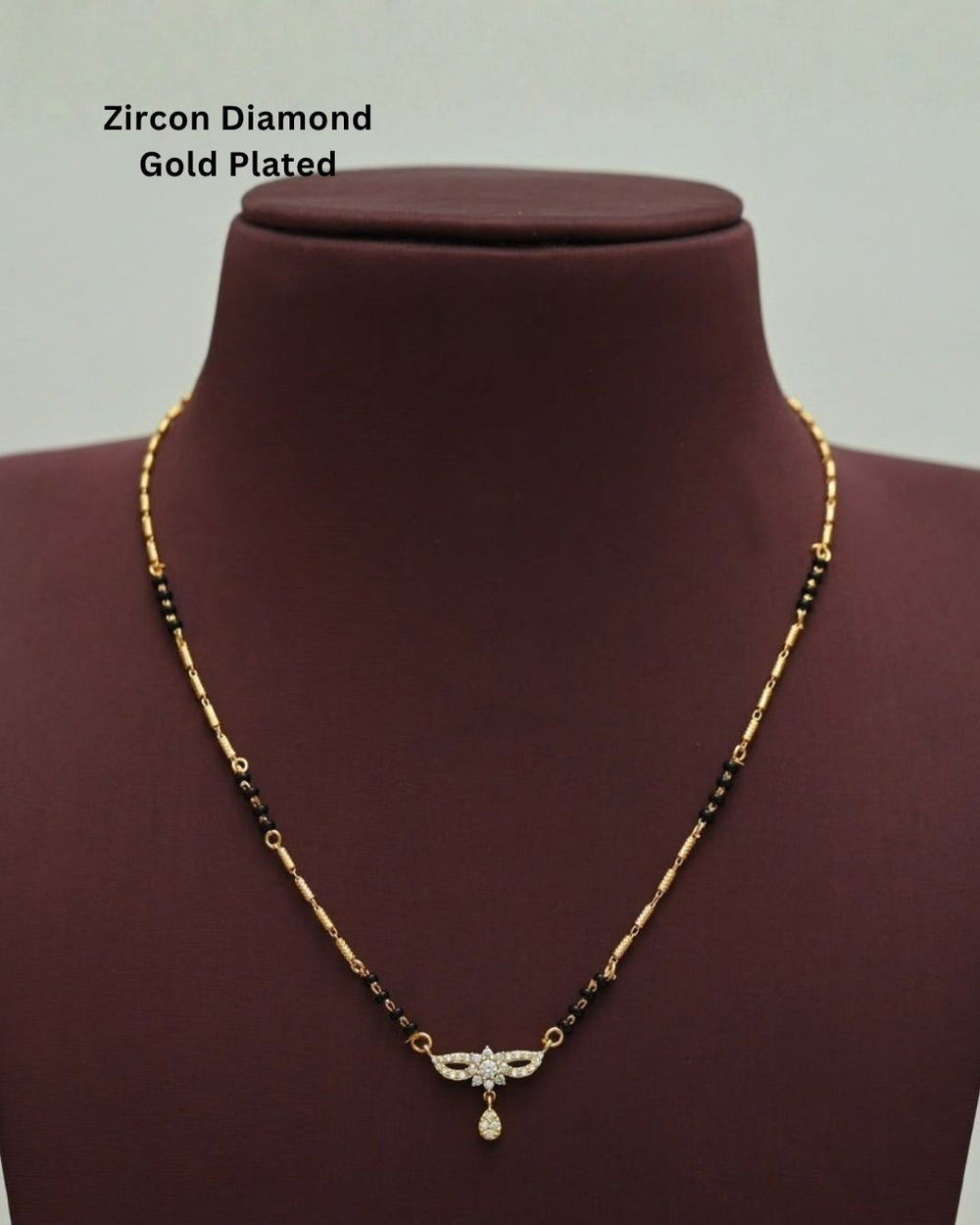 Stylish gold plated mangalsutra featuring black beads, delicate gold detailing, a sparkling CZ pendant, and a teardrop embellishment, perfect for everyday and traditional wear.