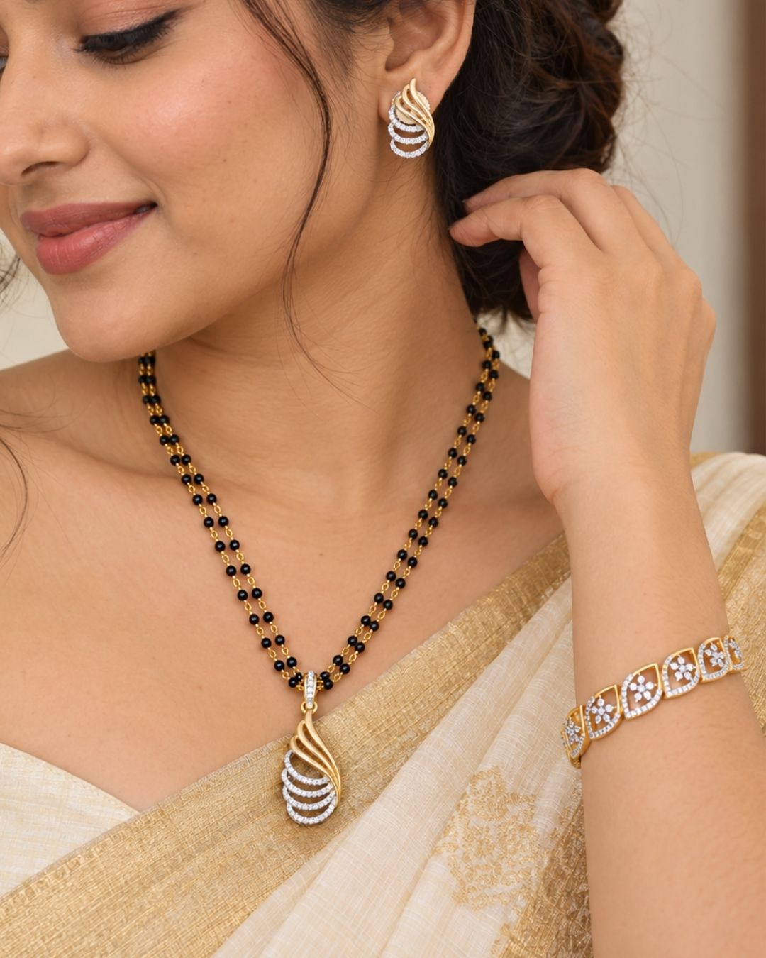 Designer gold plated mangalsutra set for women featuring black bead strands, sparkling zircon detailing, an elegant curved pendant, matching earrings, and bracelet, perfect for everyday and traditional wear.