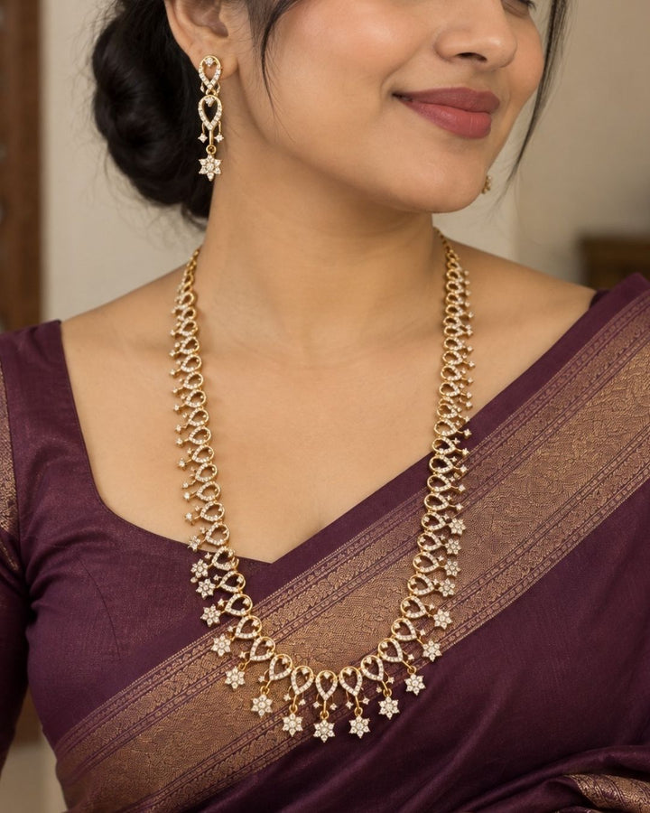 Traditional gold plated necklace set for women featuring ruby-red and emerald-green stones, sparkling accents, intricate teardrop patterns, and matching earrings, perfect for festive and ethnic wear.