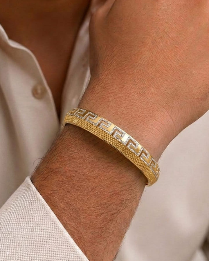 Stylish gold plated statement bangle featuring a textured gold finish and a continuous Greek key geometric design with silver-tone detailing. Perfect for festive occasions, traditional outfits, parties, weddings, and everyday styling.