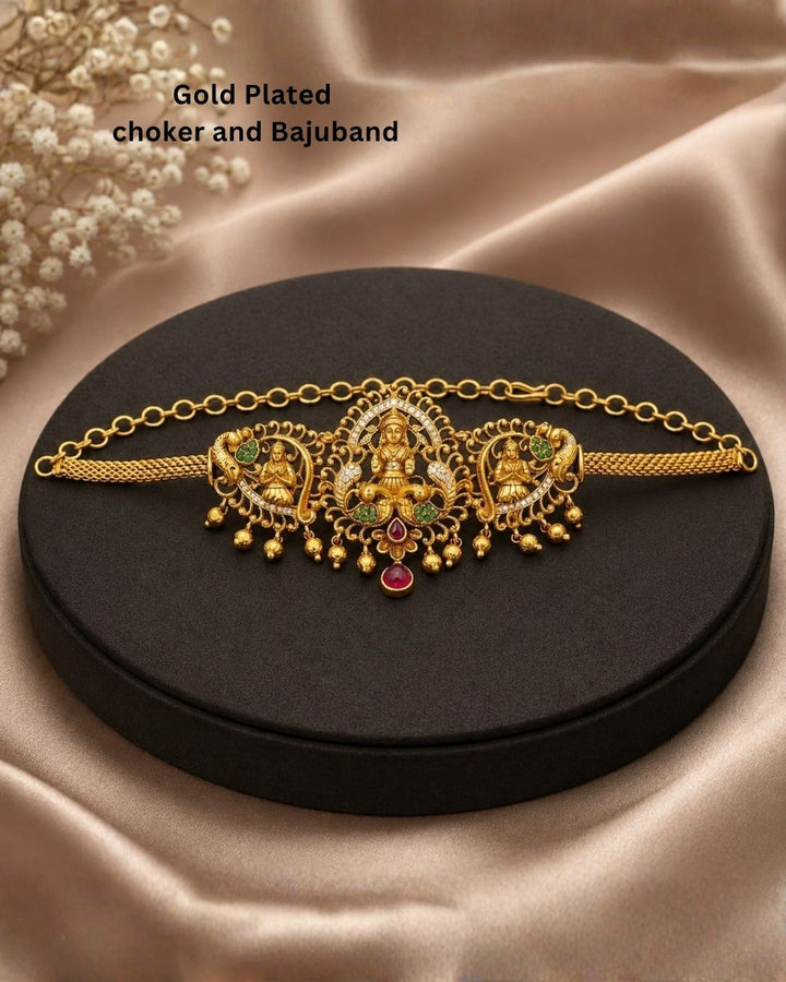 Shop Gold Plated 2-in-1 Choker &amp; Bajuband featuring an elegant Goddess Lakshmi centerpiece, intricate peacock motifs and green-pink stone detailing. Perfect for weddings, festivals, traditional wear and special occasions. COD available at Zevana.