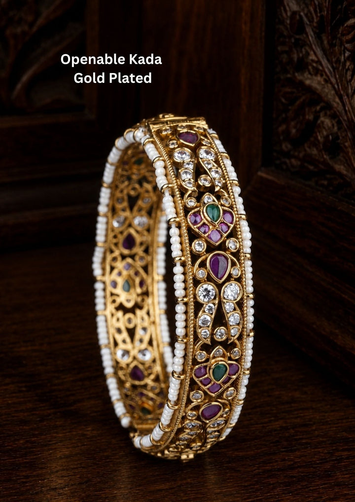 Beautiful Jadau Kundan gold plated openable kada adorned with ruby, green stones, dazzling Kundan work, and pearl detailing. Perfect for weddings, festive occasions, traditional wear, and premium gifting.