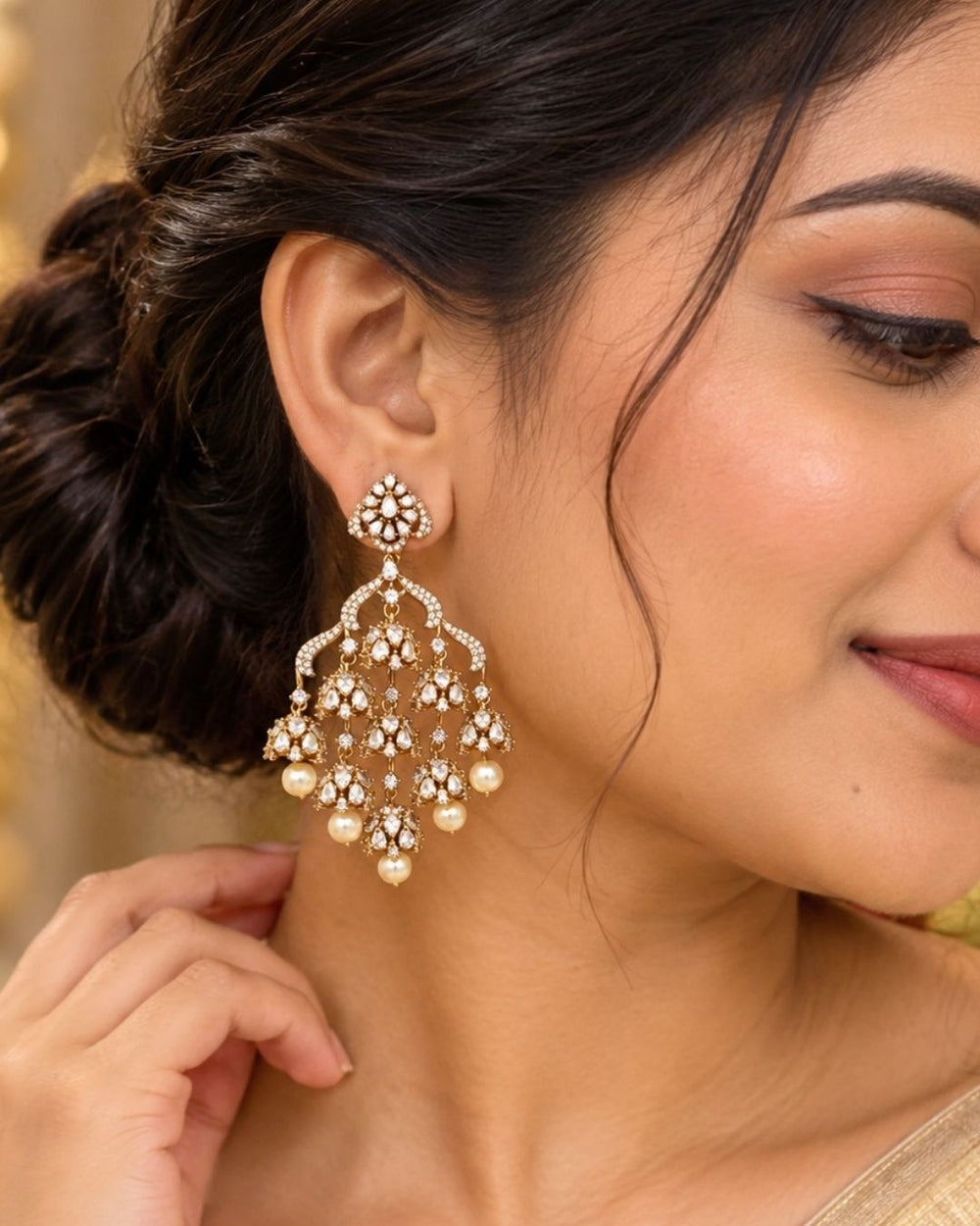 Modern Zircon Diamond gold plated heavy chandelier earrings. The design features a diamond-shaped top stud encrusted with white CZ stones, connecting to a wide arches layout. Suspended from the frame are three layers of small, delicate jhumka domes covered in sparkling American diamonds, finished with large hanging white pearls. Perfect for office, wedding, festivals
